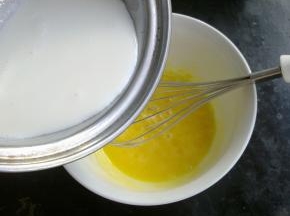 把热牛奶缓慢的加到蛋黄里，同时打蛋器要不停的搅拌蛋黄。