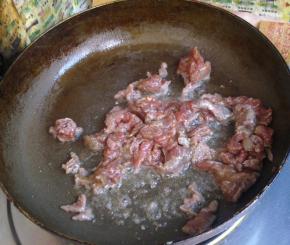 锅里倒油，下入牛肉滑散，表面变色捞出。