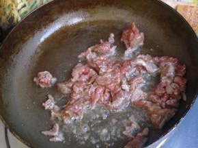 锅里倒油，下入牛肉滑散，表面变色捞出。