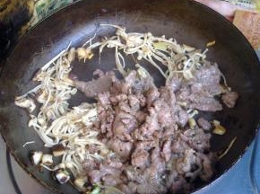 金针菇变软后倒入牛肉。