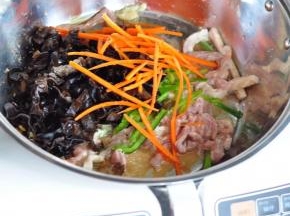 再将切好的胡萝卜丝、青椒丝、木耳丝放入，撒一点盐。