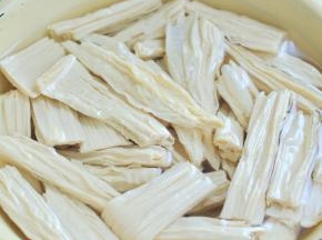 腐竹掰成段，用水浸泡变大。