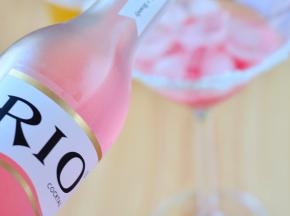 将蜜桃味的RIO鸡尾酒，沿勺背缓缓倒入杯中。