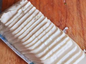 将内脂豆腐小心从盒中取出，切成薄厚一致的片状。