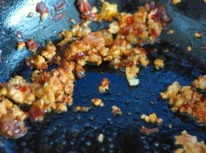 炒出红油后，放入猪肉末，倒入料酒、生抽，同时放入葱、姜、蒜。