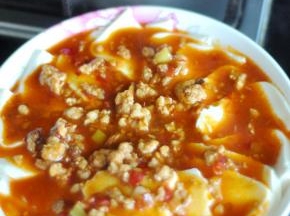 将锅中的酱汁倒在豆腐上。