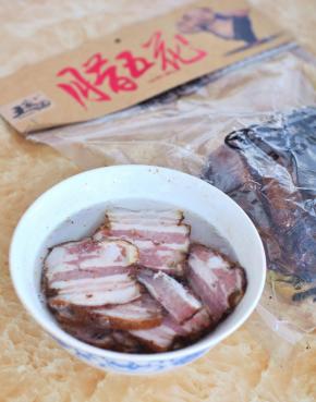 将腊五花肉切片，用开水浸泡2小时，下锅前用清水冲洗一下表面的油渍。
