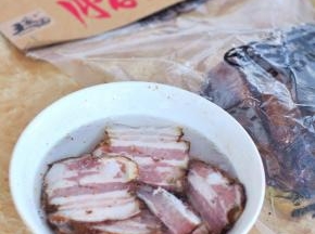 将腊五花肉切片，用开水浸泡2小时，下锅前用清水冲洗一下表面的油渍。