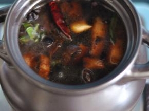 将五花肉移入砂锅中，加满水，放入干辣椒、香叶，水开后转小火煲煮一个小时。