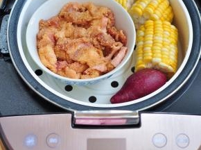 第二层将电饭煲自带的蒸笼盖上，将粉蒸肉放入，再顺便蒸个紫薯和玉米。