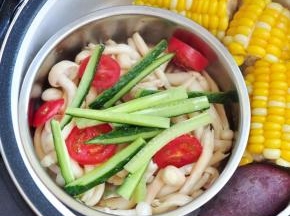 圣女果切片，与白玉菇和切成条状的黄瓜，一起放入另一个容器内，加入盐和油拌匀。在程序剩下8分钟时，将粉蒸肉取出，将蔬菜放入，直到程序结束，再焖5分钟，食物就全部都熟了。