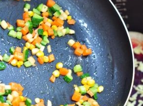 将胡萝卜丁、黄瓜丁、杏鲍菇丁、玉米粒加少许盐，用油炒到6成熟。倒在饼皮上面，摊匀。