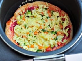 还剩下25分钟的时候，打开盖子，把饼皮边缘也抹上一层番茄酱，表面再撒一层马苏里拉奶酪，关上盖子继续工作至时间结束。