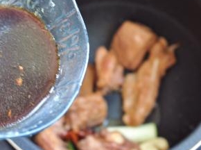 将腌排骨的汤汁加少许水，倒入电饭煲内。