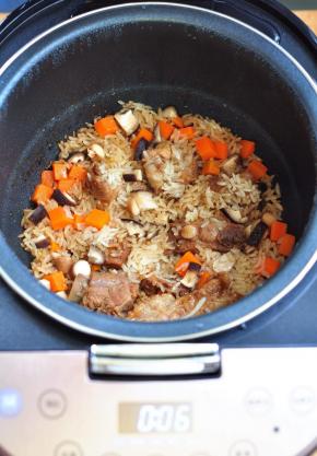 将生米、胡萝卜丁、香菇丁倒入电饭煲中，加适量的水，再用一个快煮饭程序，将米饭焖好。