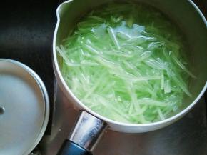 热水中滴几滴油，加少许盐，下笋丝，即刻捞出。