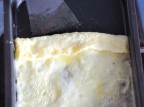 用煎锅自配的铲子，轻轻将边沿铲起，由上至下卷起。