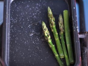锅里倒少许油，放入芦笋，再撒一点盐，煎至表面脆绿。