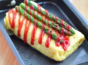 最后将芦笋摆放在厚蛋烧上面，挤上番茄酱。