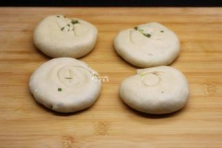 从一边卷起，再从一端口卷起，压扁；油葱饼胚就做好；