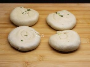 从一边卷起，再从一端口卷起，压扁；油葱饼胚就做好；