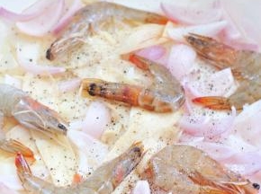 烘烤10分钟后，取出铸铁锅，将大虾摆上，表面撒上黑胡椒颗粒。再放回烤箱烘烤10分钟。