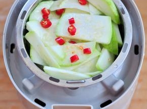 将西葫芦切片，加入盐、油、生抽拌匀，表面撒上红辣椒。等电饭盒工作了40分钟后，将上层的米取出，将菜放上。直到烹饪时间结束。