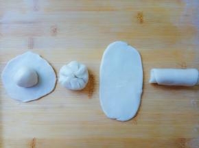 面团松弛好后。取一个A油皮面团，擀圆片，一个B油酥面团放在上面，像包包子一样收口。收口朝下，擀成牛舌状，从下向上卷起。