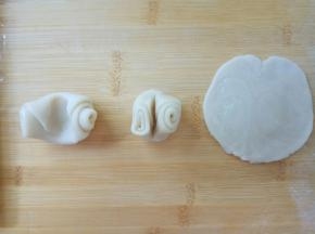 松弛好后，取一个面卷，用手指在中间按一下，左右两头向中间对折，向下按扁，擀成中间厚边缘薄的圆片。