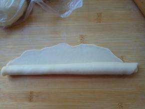 从下向上卷起，至边缘薄的位置处收口捏紧。再向左右两边搓成长约30厘米的长条。