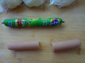 取玉米肠，剥去外衣，一切两半，薄薄的切去两头圆弧形肠肉，这样两边都是平齐的截面。