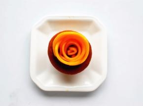 取头部略小的芒果片卷起，摆出花芯。中间较大的芒果片，摆出外围，越往最外层，越要摆得错落有致。