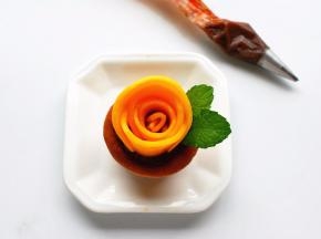 芒果花摆好后，在适合的位置挤出少许巧克力豆沙，插上薄荷叶装饰即可。