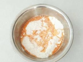 面粉中倒入适量的胡萝卜汁，发酵粉一起放入。