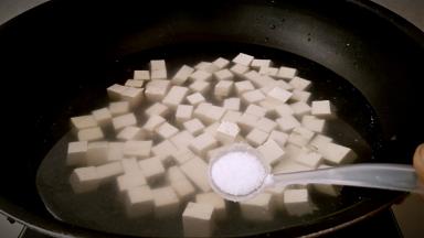 锅中放入清水，放入豆腐，盐2克，滚煮1分钟。