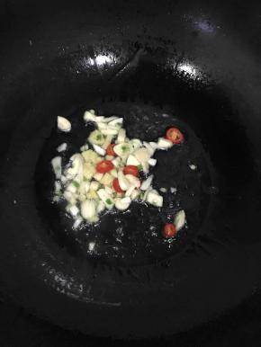 热锅冷油，加入切好的蒜瓣、辣椒、生姜，煸炒出香味。