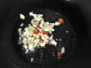 热锅冷油，加入切好的蒜瓣、辣椒、生姜，煸炒出香味。