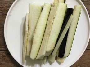 茄子切条或者切滚刀块都可以。锅中加水，倒入一点盐烧开，把切好的茄子放入热水锅中煮4分钟左右捞出倒入砂锅。