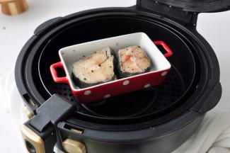 在两面均匀抹上一小撮海盐、黑胡椒、橄榄油，码放在烤盘里，盖上锡纸，放入空气炸锅中。