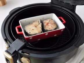 在两面均匀抹上一小撮海盐、黑胡椒、橄榄油，码放在烤盘里，盖上锡纸，放入空气炸锅中。