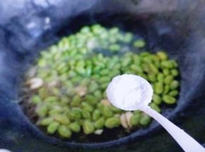 加入盐，白砂糖，将毛豆炒至断生。