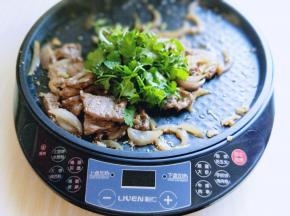 关火加入切好的香菜，继续翻炒，借助电饼铛的余温将香菜炒熟。