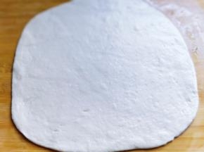 将面团用擀面杖擀成长方形。（可以再面板上涂上少许食用油，防沾。）