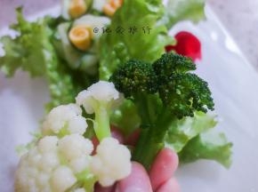 将油纸垫在盘子上先铺上生菜打底然后摆上各种蔬菜