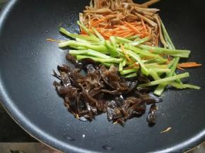 依次放入胡萝卜丝、尖椒丝，最后加木耳丝快速滑炒一下，全部拌匀后盛出备用。