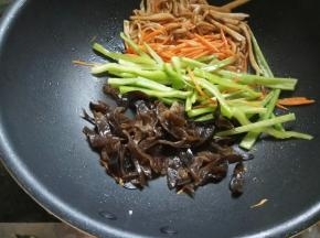 依次放入胡萝卜丝、尖椒丝，最后加木耳丝快速滑炒一下，全部拌匀后盛出备用。