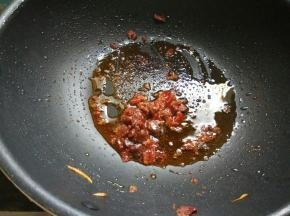 倒入少许油，下郫县豆瓣酱、料酒，炒出红油。