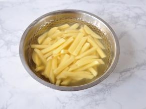 将土豆切成约1厘米左右宽的长条，放在水中加一勺盐清洗至无淀粉，尽量多换几次水。