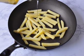 加入少许油抖匀。不要多，以薯条上能均匀沾满就行