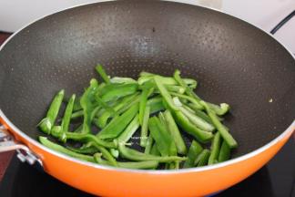 锅中放油，大火爆炒青椒六成熟；